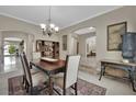 Formal dining room with a dark wood table, light-colored chairs, and arched doorways at 9046 Barium Rock Ave, Las Vegas, NV 89143