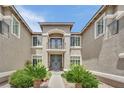 Inviting home entrance with manicured landscaping and a charming balcony above the doorway at 9046 Barium Rock Ave, Las Vegas, NV 89143