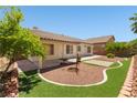 Private backyard features a patio, manicured desert landscaping, and artificial grass at 9282 W Viking Rd, Las Vegas, NV 89147