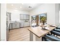 Well-lit kitchen with stainless steel appliances, gray cabinetry, a breakfast bar, and sliding glass doors to the outside at 10301 Coal Creek Pl, Las Vegas, NV 89134