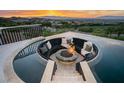 Incredible outdoor view of a fire pit surrounded by a pool and overlooking a city and mountain view at 1228 Stellar Rim Ct, Henderson, NV 89012
