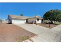 Single-story home with a two-car garage, desert landscaping, and a paved driveway at 1620 Yellow Rose St, Las Vegas, NV 89108