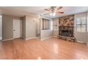 Spacious living room featuring hardwood floors, a stone fireplace, and a ceiling fan at 1729 Yellow Rose St, Las Vegas, NV 89108