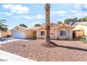 Charming single-story home featuring a desert landscape, tile roof, and inviting arched entryway at 3145 Tarpon Dr, Las Vegas, NV 89120