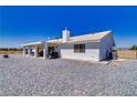 This rear exterior view features a covered patio and desert landscaping at 3581 Margarita Ave, Pahrump, NV 89048