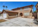 Expansive driveway leading to a charming home with a brick-arched entrance, ideal for welcoming guests at 4990 Spring Oak St, Las Vegas, NV 89120