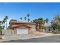 Two-story home boasting a large driveway and desert landscaping, offering a blend of comfort and style at 4990 Spring Oak St, Las Vegas, NV 89120