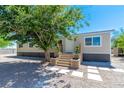 Inviting single-story home with gravel yard, wooden steps, and manicured potted plants near the door at 5822 E Carey Ave, Las Vegas, NV 89156