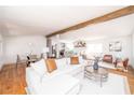 Open-concept living room with exposed beams, hardwood floors, and seamless flow to kitchen and dining at 5822 E Carey Ave, Las Vegas, NV 89156