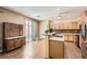 Well-lit kitchen boasts wooden cabinets, stainless appliances, and a bar-style counter for casual dining at 6329 Orange Hue St, North Las Vegas, NV 89031