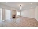 Spacious living room with a modern fireplace, sleek lighting fixtures, and wood-look floors at 6509 Alpine Winter Ct, Las Vegas, NV 89149