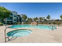 Resort-style pool area with a hot tub, waterfall feature, and lounge chairs at 6955 N Durango Dr # 2081, Las Vegas, NV 89149