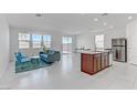 Open-concept living area with modern furnishings, white tile flooring, and lots of natural light at 7256 Saxby Ave, Las Vegas, NV 89113