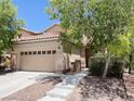 Inviting two-story home with a spacious two-car garage, manicured yard, and tiled roof at 740 White Grotto St, Las Vegas, NV 89138