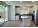Open kitchen with granite countertops, stainless steel appliances, island, and access to outdoor patio at 740 White Grotto St, Las Vegas, NV 89138