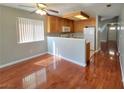 An open-concept dining area and kitchen with wood floors, cabinetry, and a view to the entrance at 7614 Isley Ave, Las Vegas, NV 89147
