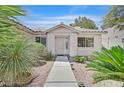 Inviting home entrance surrounded by drought resistant landscaping and a lighted walkway at 7645 Falconwing Ave, Las Vegas, NV 89131