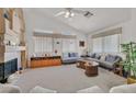 Bright living room with vaulted ceilings, fireplace, and large windows with custom treatments at 7645 Falconwing Ave, Las Vegas, NV 89131