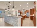 Gourmet kitchen featuring granite countertops, pendant lighting, stainless appliances, and custom cabinetry at 7668 Friendly Breeze Ct, Las Vegas, NV 89123