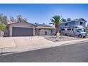 Street view of a quaint one-story home with desert landscaping and RV parking on a sunny day at 823 Cherry Dr, Henderson, NV 89002
