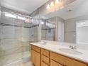 Bright bathroom featuring double sinks, a large mirror, and a modern glass-enclosed shower at 8739 Cerrito Canyon Ct, Las Vegas, NV 89148