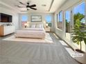 Bright main bedroom with plush carpet, balcony access, and ample natural light from large windows at 9319 Bronze River Ave, Las Vegas, NV 89149