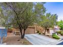 Two-story home with attached two-car garage, mature trees, and desert landscaping at 9629 Toy Soldier St, Las Vegas, NV 89178