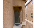 Stucco home featuring a neutral front door with an archway and low maintenance landscaping at 9629 Toy Soldier St, Las Vegas, NV 89178