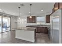 Contemporary kitchen features stainless steel appliances, granite countertops, island, pantry, and backyard view at 9917 Fletcher Peak Ave, Las Vegas, NV 89178