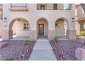 Charming home featuring an arched entryway, covered porch, and well-maintained landscaping at 10345 Howling Coyote Ave, Las Vegas, NV 89135