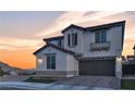 Charming two-story home with a tile roof, warm exterior lighting, and well-maintained landscaping, inviting curb appeal at 10729 Marathon Bell Ln, Las Vegas, NV 89129