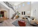 Bright living room with high ceilings, iron stair railing, and comfortable seating, with a decorative rug at 11707 Longworth Rd, Las Vegas, NV 89135