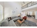 Open concept living room, with modern furnishings, hardwood floors, and a view into the dining area at 11707 Longworth Rd, Las Vegas, NV 89135