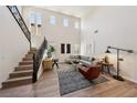 Spacious living room showcasing the staircase, tall ceilings, and large windows for lots of natural light at 11707 Longworth Rd, Las Vegas, NV 89135