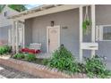 Welcoming front porch with swing seat, hanging plants, brick detail, and pale pink front door at 1320 Wengert Ave, Las Vegas, NV 89104