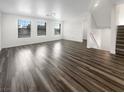 Spacious room showcasing wood floors, bright white walls, and a staircase to the second floor at 148 Campbelltown Ave, Henderson, NV 89015