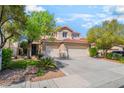 Charming two-story home with attached two-car garage and well manicured landscaping at 1553 Ravanusa Dr, Henderson, NV 89052