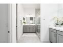 Bright bathroom with double vanity, modern fixtures, and a glass shower at 174 Cabo Cruces Dr, Henderson, NV 89011