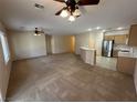Spacious living area offering ceiling fans and easy access to the adjacent kitchen with modern appliances at 2224 Waterton Rivers Dr, Henderson, NV 89044