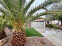 Inviting single-story residence with lush landscaping, artificial grass, and a spacious driveway at 2558 Divine Sky Dr, Henderson, NV 89044