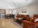 Bright and open living room with tile flooring and comfortable seating that leads to the dining area and kitchen at 2558 Divine Sky Dr, Henderson, NV 89044