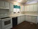 Galley style kitchen with white cabinets, white appliances and vinyl floors at 2920 Malibou Ave, Pahrump, NV 89048