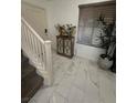 Bright foyer with marble flooring, staircase, and view of a large window at 369 Stone Fly Rd, North Las Vegas, NV 89032