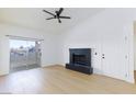Bright living room with a black brick fireplace, ceiling fan, and sliding glass doors to a balcony at 3770 Shirebrook Dr # 160, Las Vegas, NV 89115