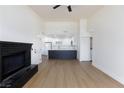 Open-concept living area with a black brick fireplace and light wood-look flooring leading to the kitchen at 3770 Shirebrook Dr # 160, Las Vegas, NV 89115