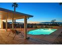 Backyard pool with a seating area, palm trees, and a view of the city skyline at 392 Waterwheel Falls Dr, Henderson, NV 89015