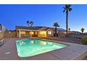 Backyard pool with patio, swing, and palm trees, perfect for relaxing and entertaining at 392 Waterwheel Falls Dr, Henderson, NV 89015