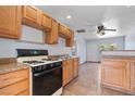 Cozy kitchen features wooden cabinets, black appliances, and tiled floors for easy cleanup at 4000 Visby Ln, Las Vegas, NV 89119
