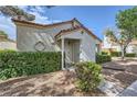 Attractive stucco home with a tiled roof and meticulously trimmed hedges at 5401 Bugle Way # 103, Las Vegas, NV 89108