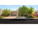 Charming home exterior featuring desert landscaping and a paved driveway leading to a two-car garage at 6056 Willow Rock St, Las Vegas, NV 89135